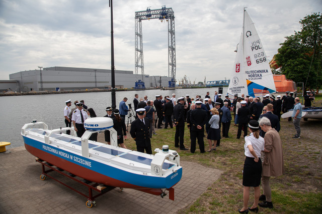 Large-scale ship model on the quay surrounded by people